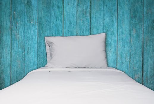 Close up white bedding and pillow on blue wooden texture background, stock photo