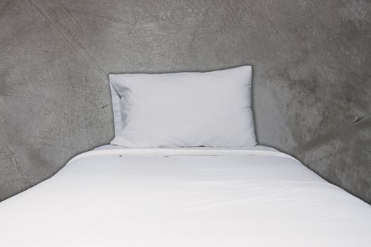 Close up white bedding and pillow on concrete texture background