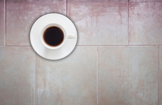 Top view of coffee cup on ceramic tiles wall texture background