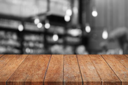 Wooden tabletop with black and white coffee shop blurred background, stock photo