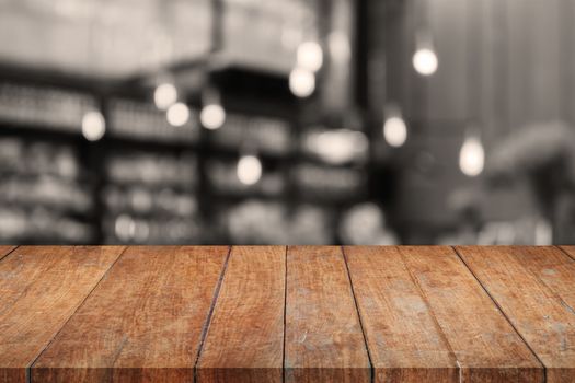 Wooden tabletop with sepia coffee shop blurred background, stock photo