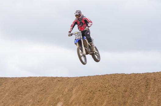 Volgograd, Russia - April 19, 2015: Motorcycle racer jumps a hill, at the stage of the Open Championship Motorcycle Cross Country Cup Volgograd Region Governor
