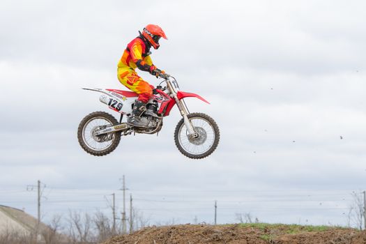 Volgograd, Russia - April 19, 2015: Motorcycle racer jumping on the trampoline in flight, at the stage of the Open Championship Motorcycle Cross Country Cup Volgograd Region Governor