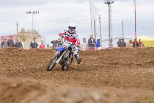 Volgograd, Russia - April 19, 2015: Motorcycle racer insured against falling outstretched leg in the corner, at the stage of the Open Championship Motorcycle Cross Country Cup Volgograd Region Governor