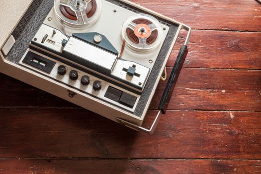 Old tape recorder on wooden background with natural lighting