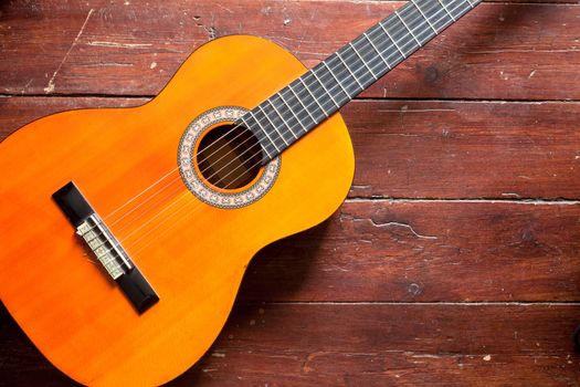 Flamenco guitar on wood background illuminated by natural daylight