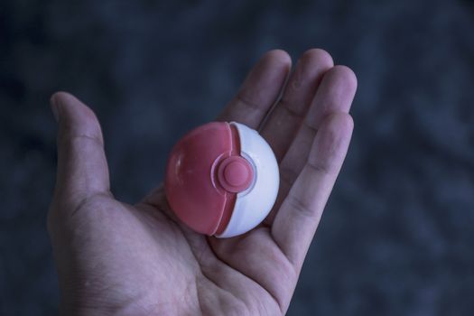 Thailand - August 20, 2016: Poke ball in Hand  (Pokemon Ball). Pokeball toy of the game Pokemon Go at Chon Buri, Thailand.