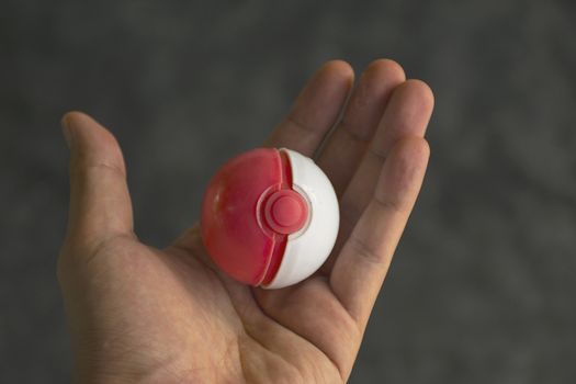 Thailand - August 20, 2016: Poke ball in Hand  (Pokemon Ball). Pokeball toy of the game Pokemon Go at Chon Buri, Thailand.