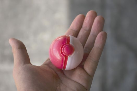 Thailand - August 20, 2016: Poke ball in Hand  (Pokemon Ball). Pokeball toy of the game Pokemon Go at Chon Buri, Thailand.