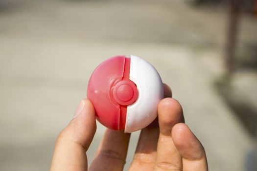 Thailand - August 20, 2016: Poke ball in Hand  (Pokemon Ball). Pokeball toy of the game Pokemon Go at Chon Buri, Thailand.