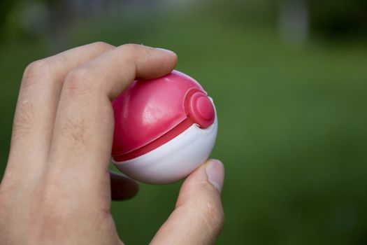 Thailand - August 20, 2016: Poke ball in Hand  (Pokemon Ball). Pokeball toy of the game Pokemon Go at Chon Buri, Thailand.