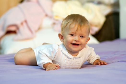 Smiling baby boy under blanket.