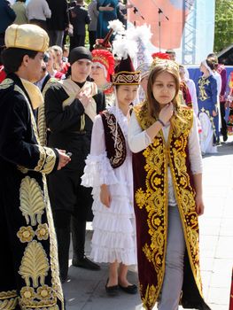 Tyumen, Russia - May 26 2012. Festival of national cultures Friendship Bridge. Peoples in Kazakh national dress ready for a concert. In the backyard are the presentation of the national dishes, show rituals are examples of arts and crafts, conduct master classes of traditional national crafts and trades and local cuisine.