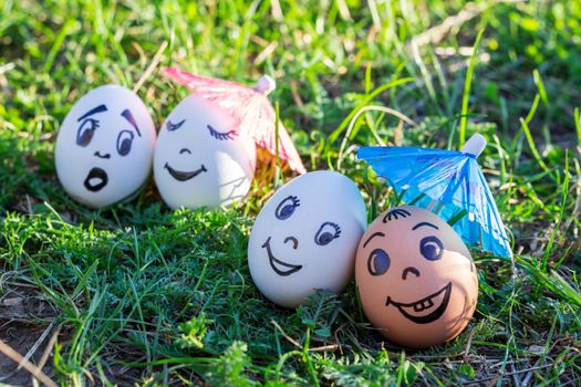 Funny eggs under umbrellas imitating happy mixed couple and indignant white couple