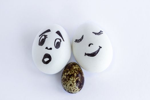 Funny eggs imitating white couple with multicolored baby on white background