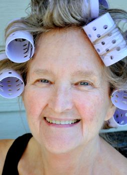 Mature female beauty wearing hair rollers.