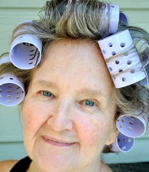 Mature female beauty wearing hair rollers.