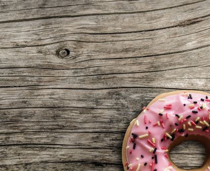 Bright Pink Donut On A Grungy Wooden Table With Copyspace