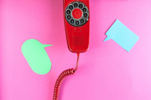 Vintage red phone and speech ballons on red background
