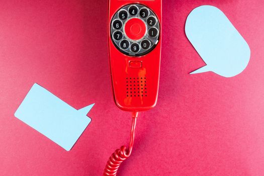 Vintage red phone and speech ballons on red background