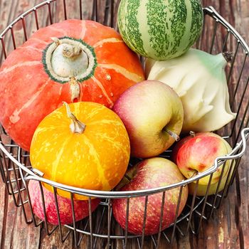 Metal basket with decorative fall pumpkins and apples