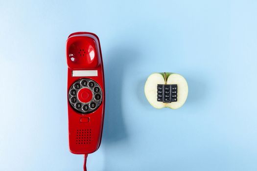 Alphanumeric apple and old red phone on a blue background