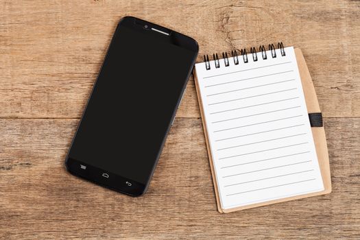 Note book  and smart phone on wood table