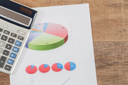 business chart and calculator on wooden desk