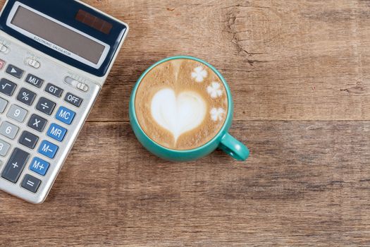 calculator  and cup of coffee on wood