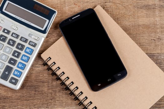 mobile phone and book note in vintage wooden desk