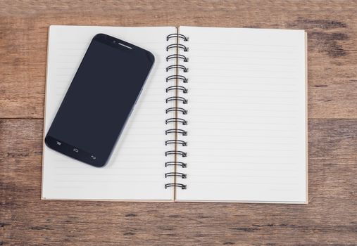 obile phone and book note in vintage wooden desk