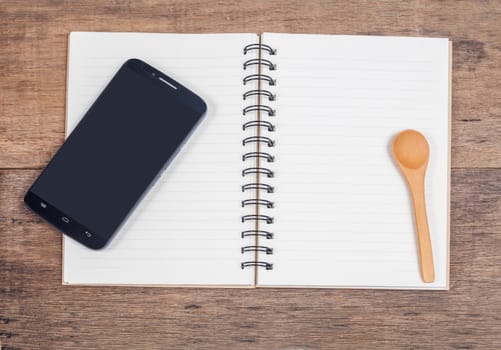 mobile phone and book note in vintage wooden desk