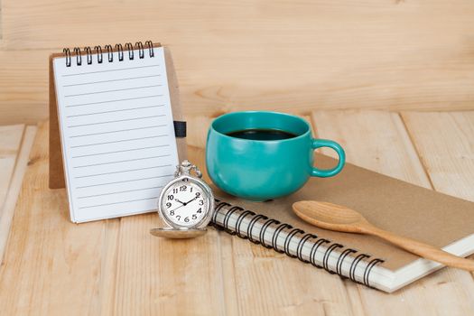 pocket watch and coffee cup on book