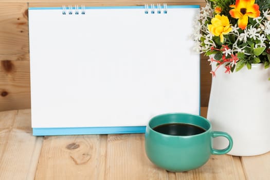 Blank calendar with cup and vase on wood