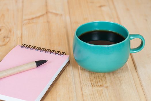 note book with cup and vase on wood table