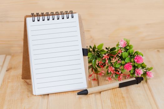 note book  and pen on wood table
