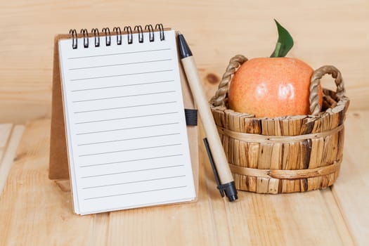 note book  and pen on wood table