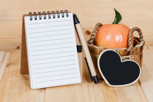 note book  and pen on wood table
