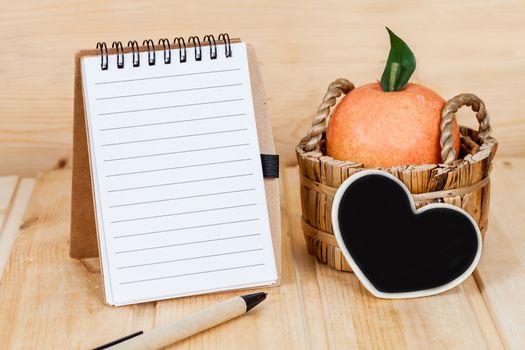 note book  and pen on wood table
