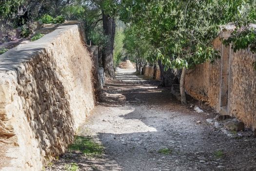 Mediterranean small road in the summer with a stone wall, texture Backgrounds.