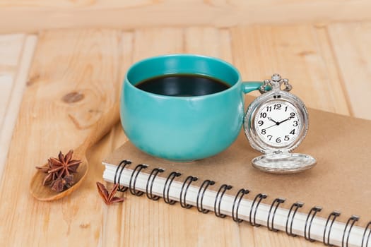 pocket watch and coffee cup on book