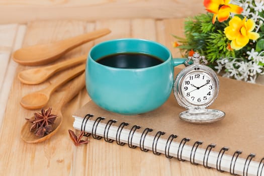 pocket watch and coffee cup on book