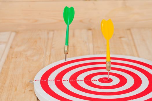 Dart arrow hitting in bullseye on dartboard