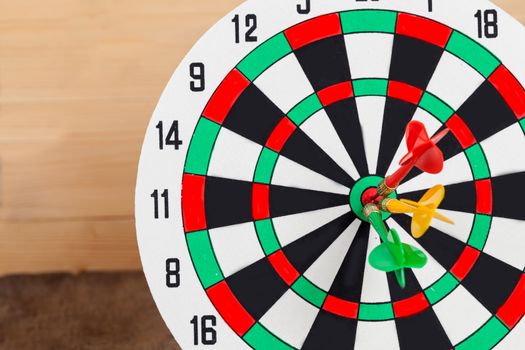 Dart arrow hitting in bullseye on dartboard
