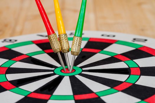 Dart arrow hitting in bullseye on dartboard
