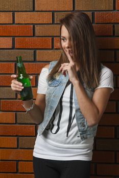 young twenty year old teenager making a silence sign to a beer