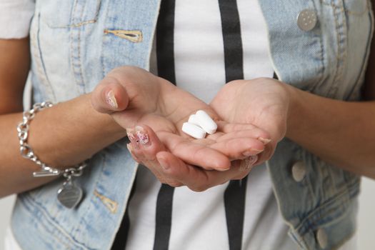 teenage girl holding white pills