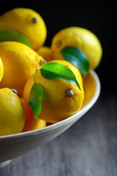 lemons with leaves on an old wooden table