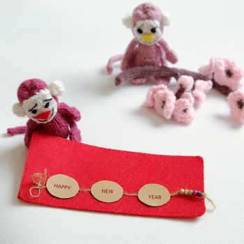 2016, year of monkey, handmade happy new year on white background, knitted monkey, funny stuffed animal, knit flower from yarn, red envelope for lucky money, sign for Vietnam Tet