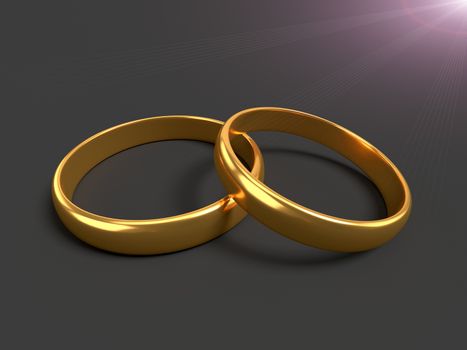 Two wedding gold rings lie on each other on black